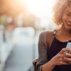a woman walking outside with her cell phone