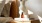 a vase with cotton stems on a bedside table
